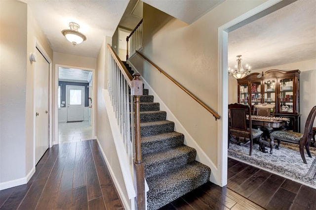 staircase featuring hardwood / wood-style floors and a notable chandelier