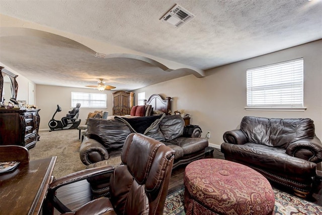 living room with ceiling fan, a textured ceiling, and carpet flooring