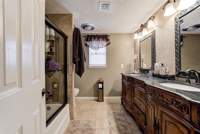 full bathroom featuring a textured ceiling, enclosed tub / shower combo, tile patterned flooring, vanity, and toilet