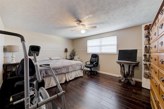 bedroom with ceiling fan, a textured ceiling, and dark hardwood / wood-style flooring