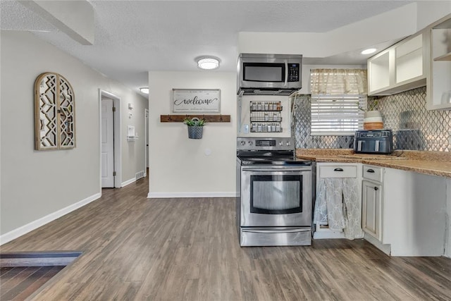 kitchen with white cabinetry, backsplash, stainless steel appliances, a textured ceiling, and dark hardwood / wood-style flooring