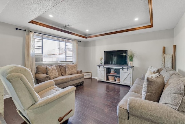 living room with a raised ceiling, ornamental molding, a textured ceiling, and dark hardwood / wood-style flooring