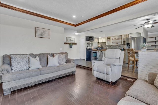 living room with ceiling fan, dark hardwood / wood-style flooring, and a textured ceiling