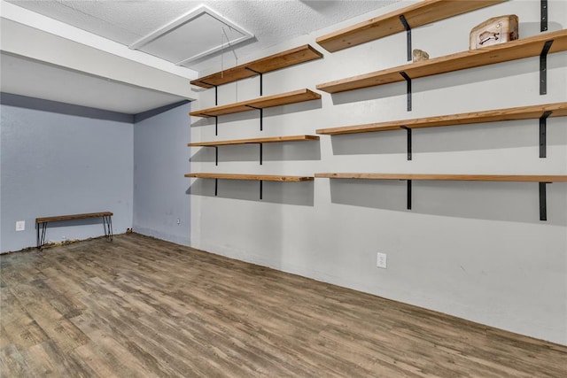 basement featuring wood-type flooring and a textured ceiling