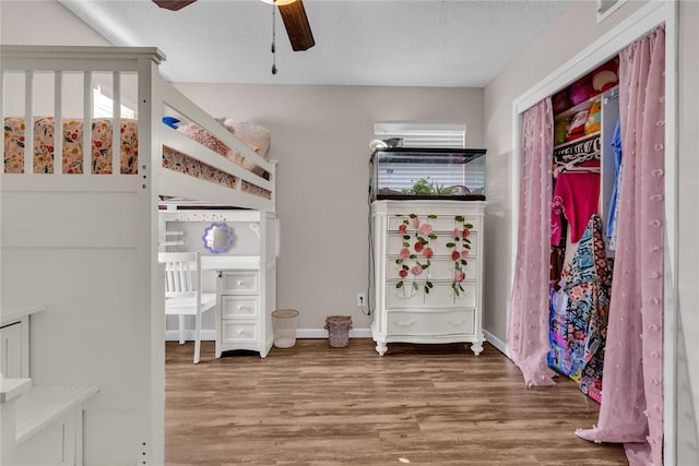 bedroom featuring a textured ceiling, wood-type flooring, and ceiling fan