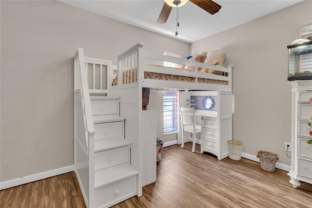 unfurnished bedroom with hardwood / wood-style flooring, ceiling fan, and a textured ceiling