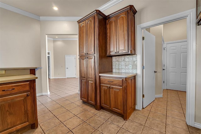 kitchen with light tile patterned flooring, ornamental molding, and backsplash