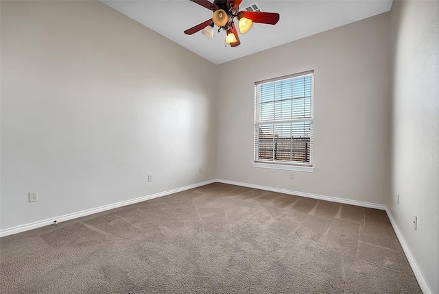 carpeted spare room featuring ceiling fan and vaulted ceiling