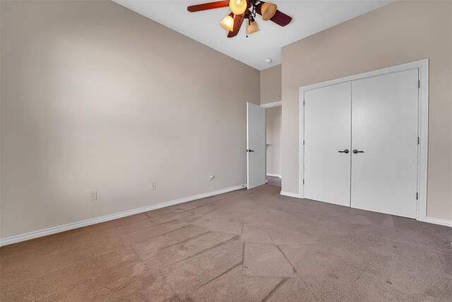 unfurnished bedroom with light carpet, ceiling fan, a closet, and lofted ceiling