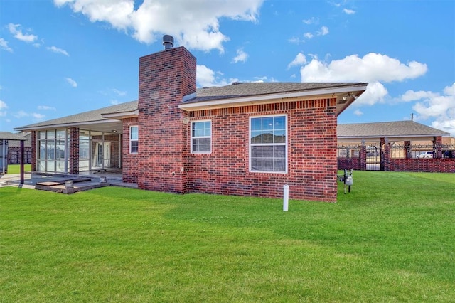 rear view of property featuring a yard and a patio