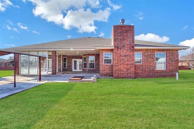 rear view of property with a patio area, french doors, and a lawn