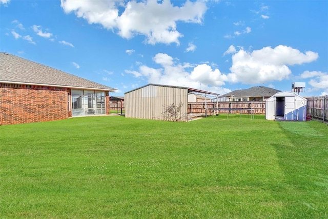 view of yard featuring a trampoline and a shed