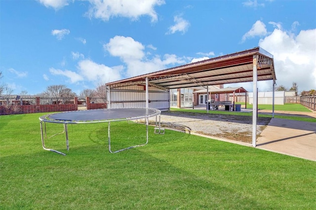 view of home's community with a lawn and a trampoline