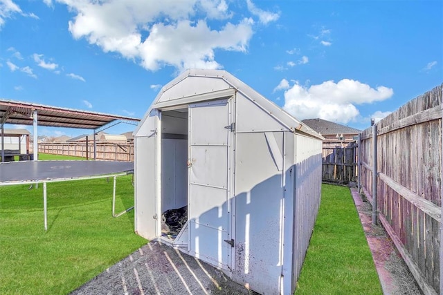 view of outbuilding with a yard and a trampoline