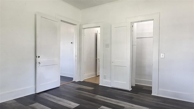 unfurnished bedroom with a closet, dark hardwood / wood-style flooring, and crown molding