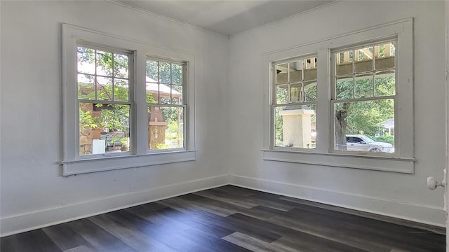 spare room featuring dark hardwood / wood-style floors and crown molding