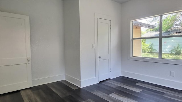 unfurnished bedroom featuring a closet and dark wood-type flooring