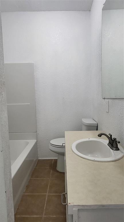 bathroom with toilet, tile patterned floors, and vanity