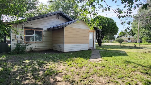 view of property exterior with cooling unit and a yard