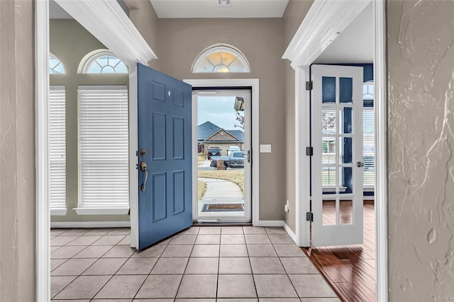 foyer with a wealth of natural light and light tile patterned flooring