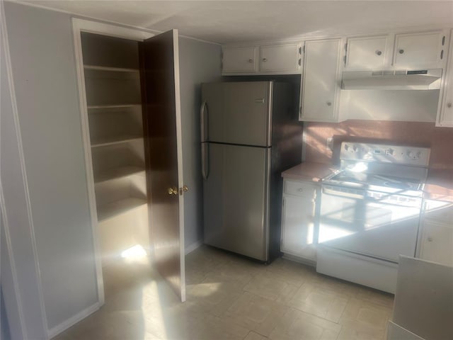 kitchen featuring white electric range oven, white cabinetry, and stainless steel fridge