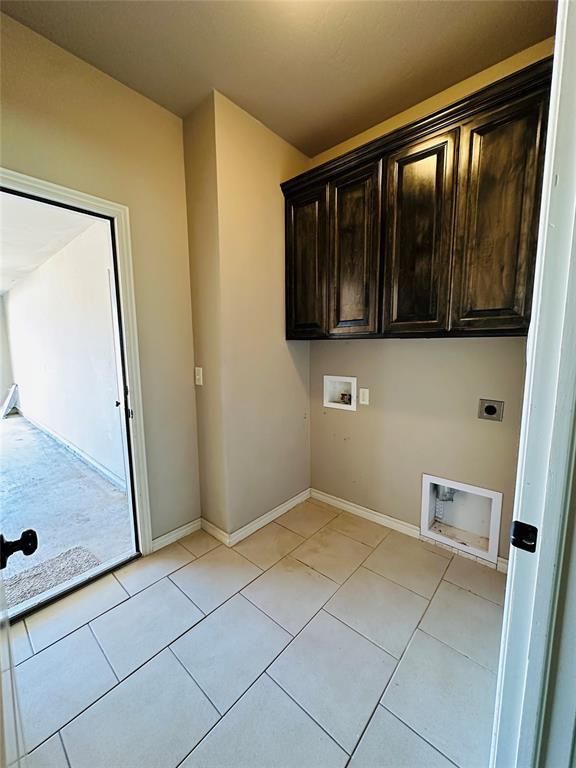 clothes washing area featuring cabinets, washer hookup, light tile patterned floors, and hookup for an electric dryer