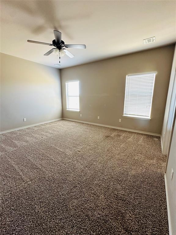 unfurnished room featuring ceiling fan and carpet