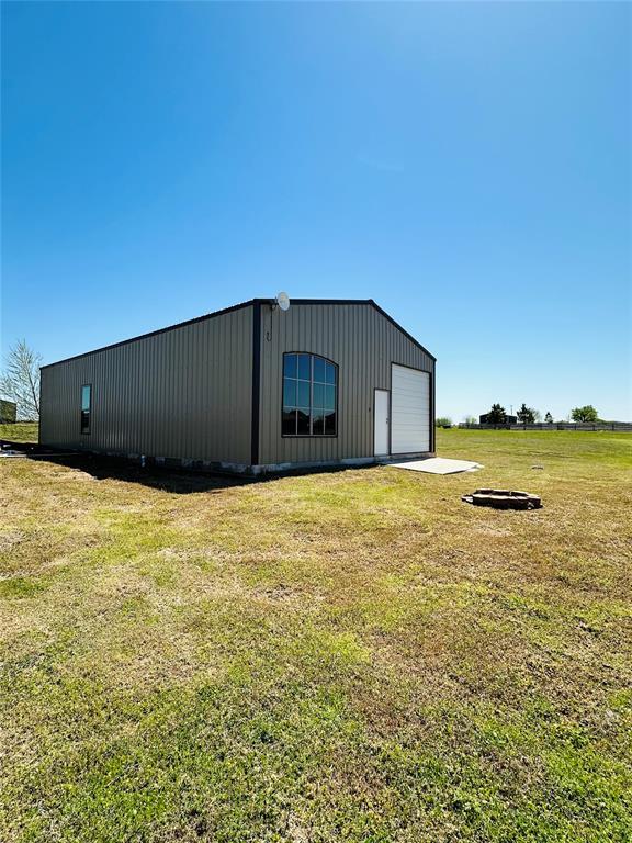 view of outdoor structure with a garage and a lawn