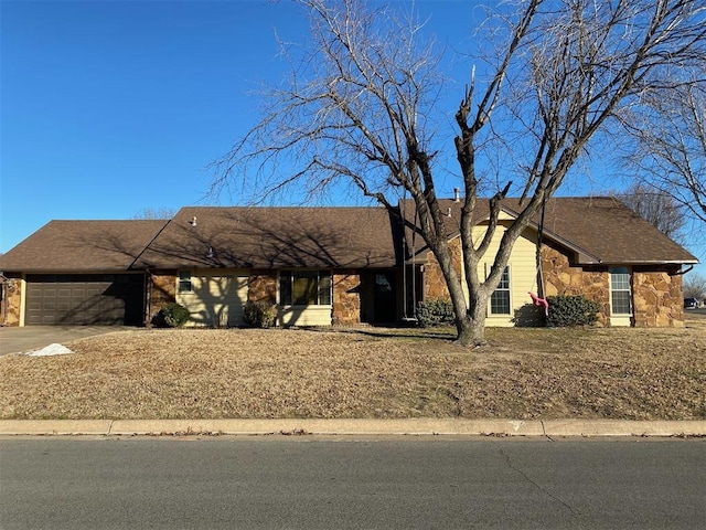 view of front facade featuring an attached garage, stone siding, driveway, and roof with shingles