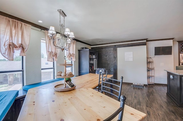 dining area with an inviting chandelier, ornamental molding, a barn door, and dark hardwood / wood-style floors