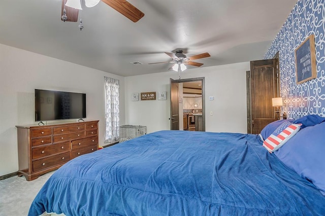 bedroom with ceiling fan, light carpet, and ensuite bathroom