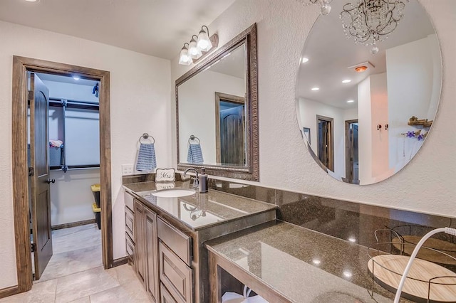 bathroom with a chandelier, tile patterned flooring, and vanity