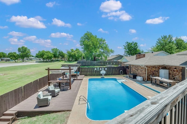 view of swimming pool featuring a deck, outdoor lounge area, a lawn, and exterior bar