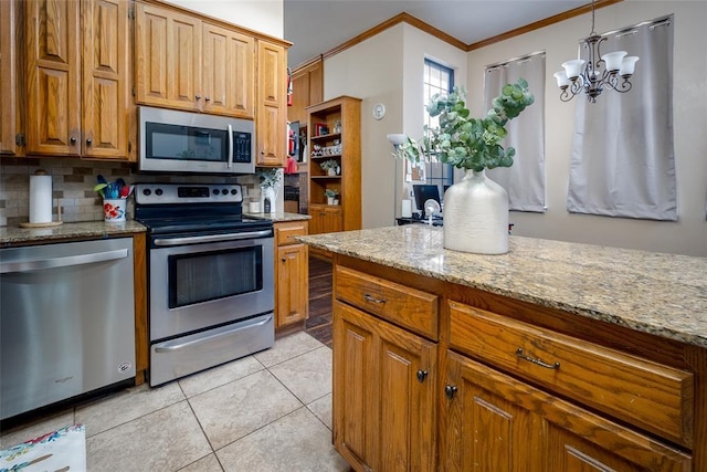 kitchen featuring appliances with stainless steel finishes, decorative backsplash, ornamental molding, a chandelier, and light tile patterned floors