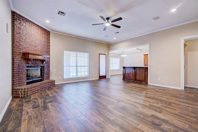 unfurnished living room with an inviting chandelier, dark hardwood / wood-style flooring, a fireplace, and ornamental molding