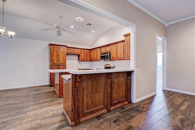 kitchen featuring dark hardwood / wood-style flooring, stainless steel appliances, hanging light fixtures, a breakfast bar, and crown molding