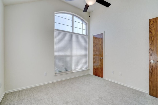 carpeted spare room featuring ceiling fan