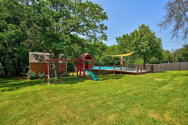 view of playground with a yard and a shed