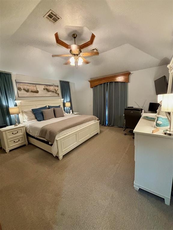 bedroom featuring ceiling fan, lofted ceiling, carpet floors, and a tray ceiling