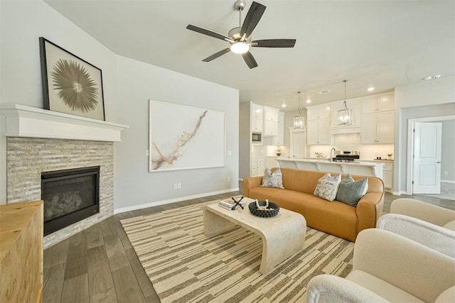 living room with a fireplace and ceiling fan