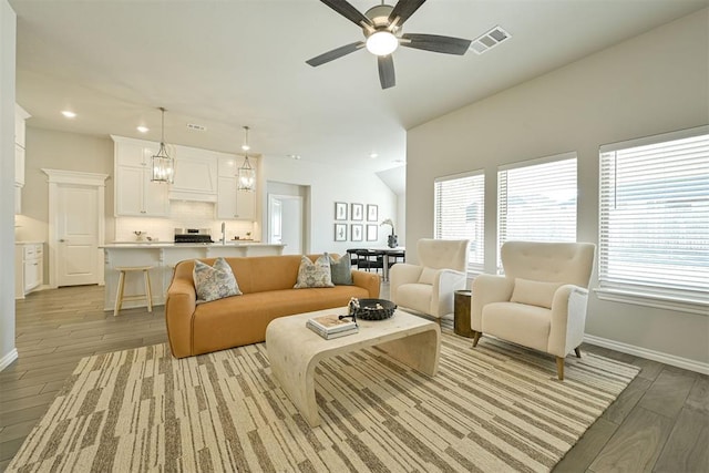 living room featuring ceiling fan, plenty of natural light, and vaulted ceiling