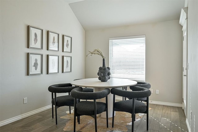 dining space featuring lofted ceiling and dark hardwood / wood-style flooring