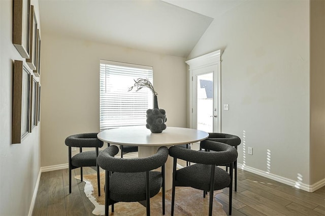 dining space with vaulted ceiling and dark hardwood / wood-style floors