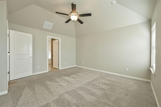 unfurnished bedroom featuring vaulted ceiling, light colored carpet, ceiling fan, and ensuite bath