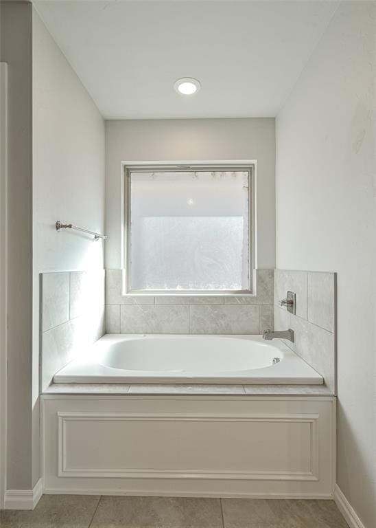 bathroom with a bath and tile patterned flooring