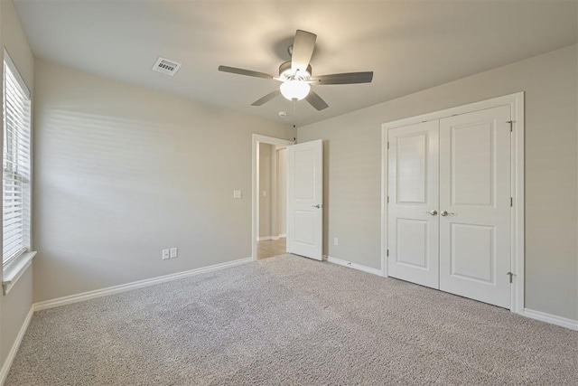 unfurnished bedroom featuring carpet flooring, ceiling fan, and a closet