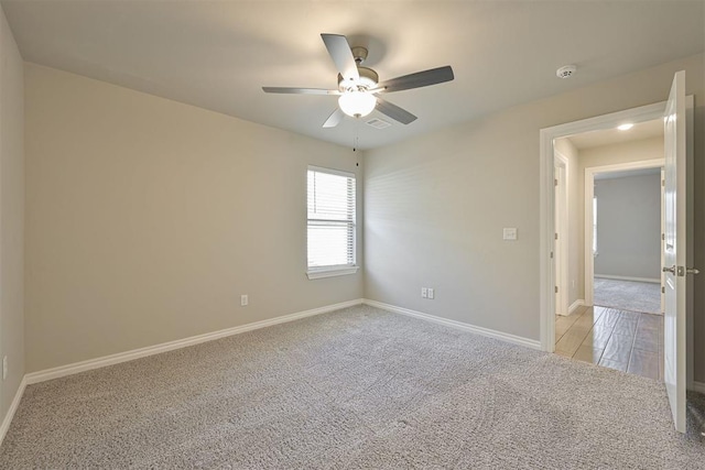 empty room with light colored carpet and ceiling fan