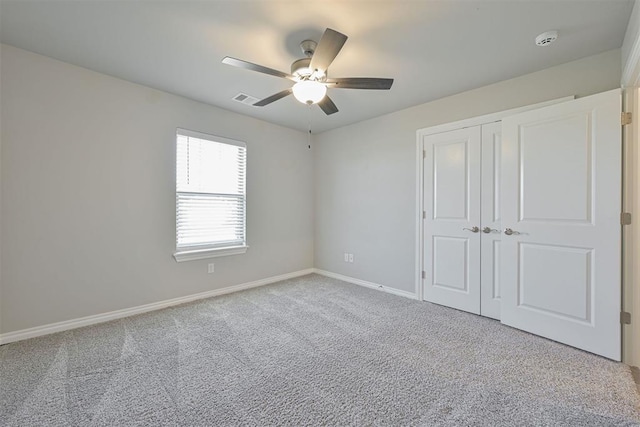 unfurnished bedroom with ceiling fan, a closet, and light carpet