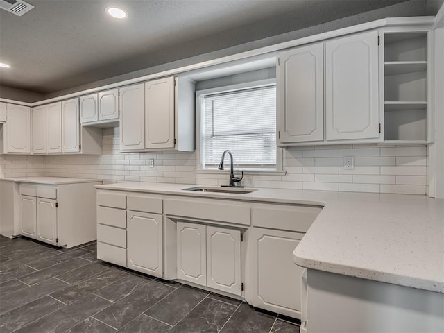 kitchen with white cabinetry, tasteful backsplash, and sink