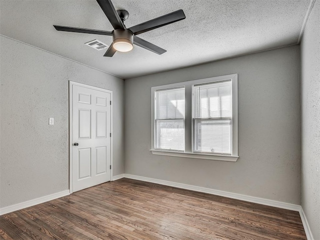 empty room featuring hardwood / wood-style flooring, a textured ceiling, and ceiling fan